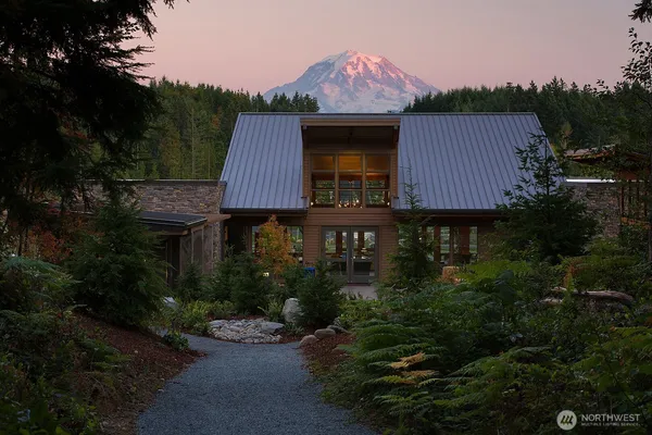 a view of a building with a big yard and large trees