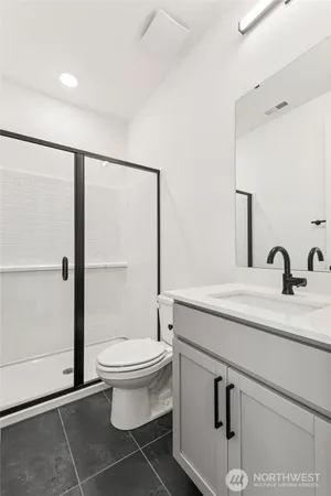 a bathroom with a sink a toilet and shower