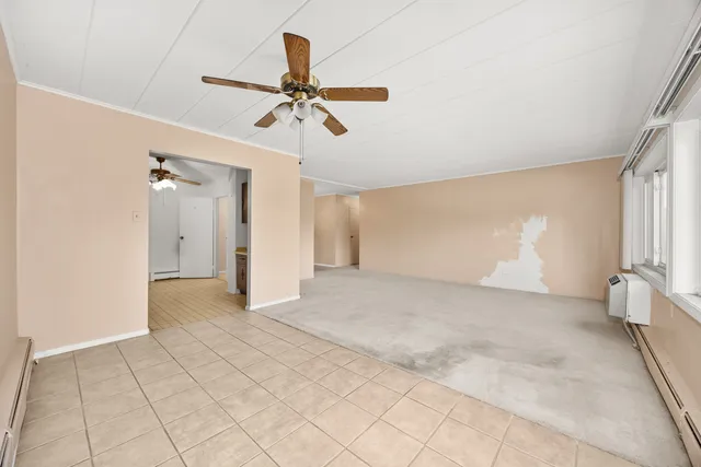 a view of a room with a ceiling fan and window