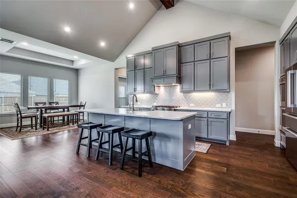 a kitchen with granite countertop a table chairs stove and cabinets