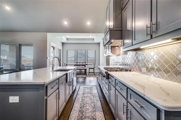 a kitchen with sink stove and cabinets