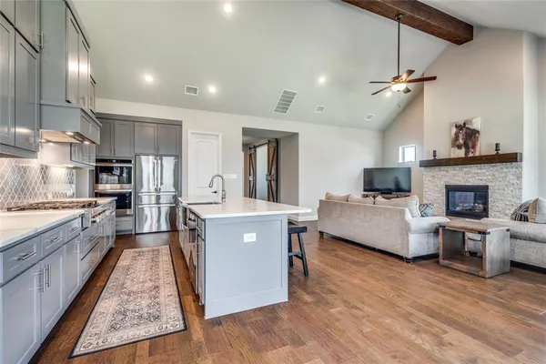 a large kitchen with cabinets a counter and chairs