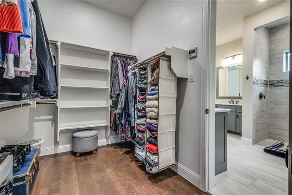 a view of walk in closet with clothes and shoes