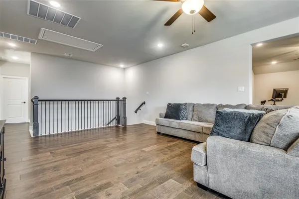 a living room with furniture and a wooden floor