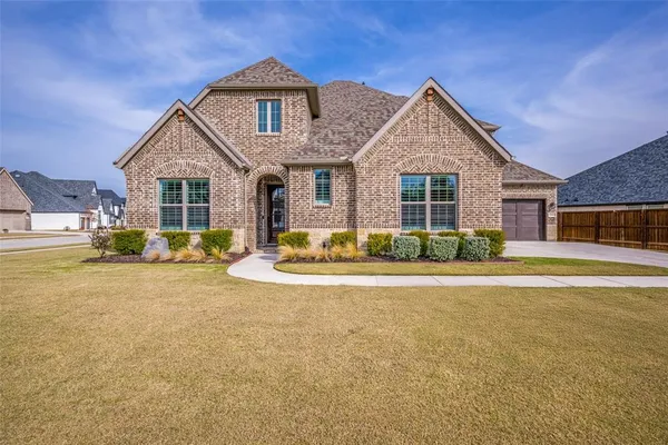 a front view of a house with a yard outdoor seating and garage