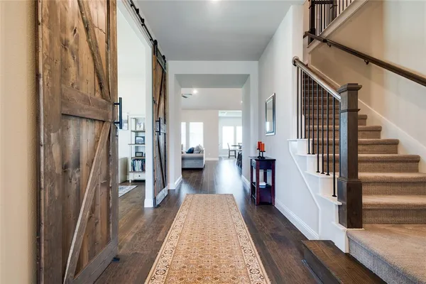 a view of a hallway with wooden floor and staircase