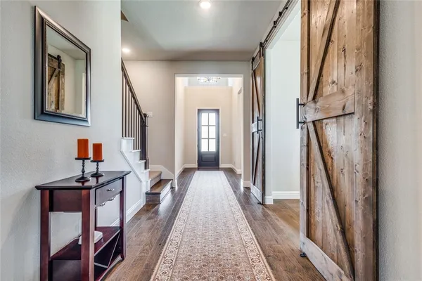 a view of a hallway with the couches and dining room view