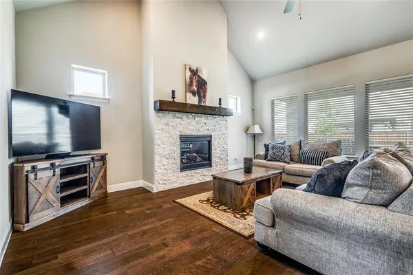 a living room with furniture a flat screen tv and a fireplace