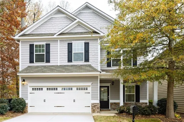 a view of a white house with large windows and a small yard