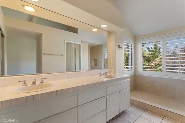 a bathroom with double vanity sinks and a bathtub