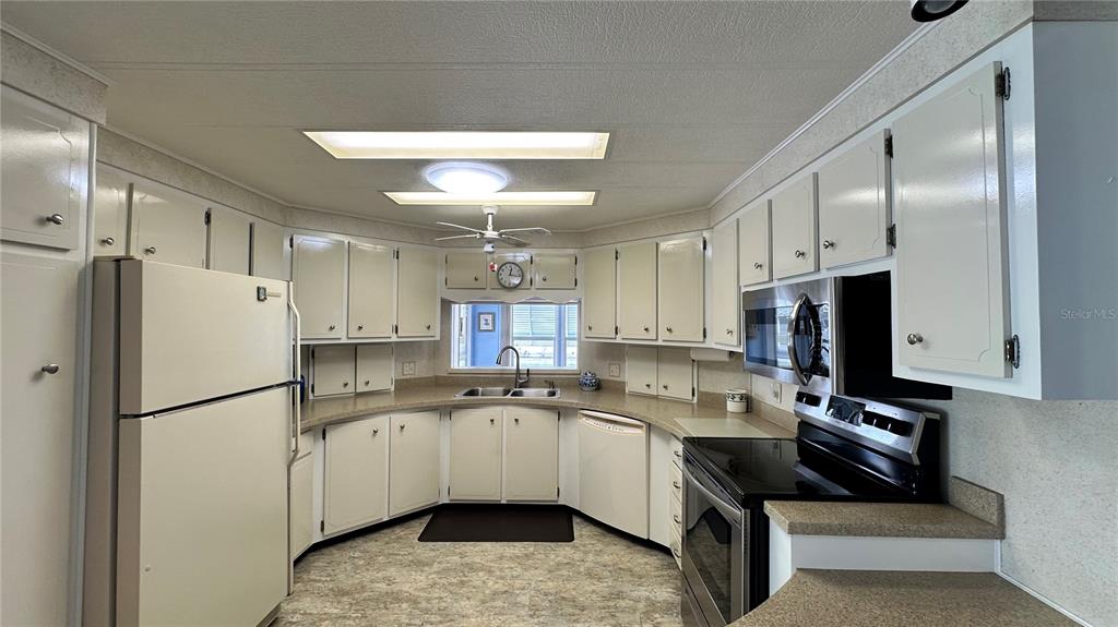 5619 Bayshore Road, Unit 163 Palmetto, FL 34221 - Photo 13 of 44 a kitchen with a sink stainless steel appliances and white cabinets
