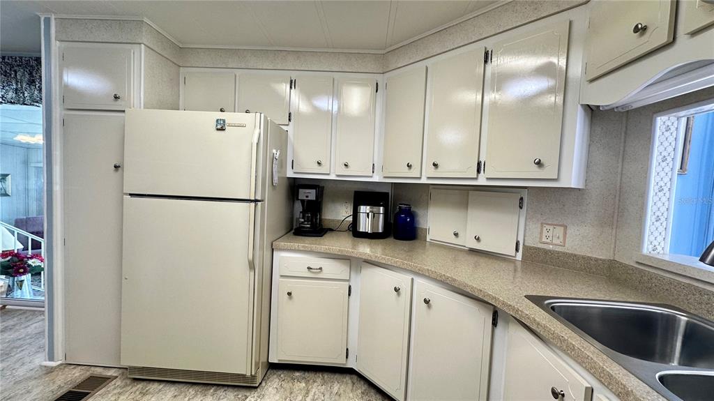 5619 Bayshore Road, Unit 163 Palmetto, FL 34221 - Photo 14 of 44 a kitchen with granite countertop a refrigerator sink and cabinets
