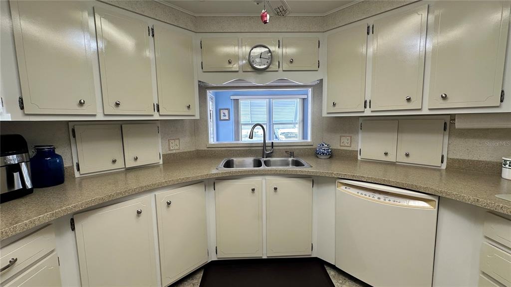 5619 Bayshore Road, Unit 163 Palmetto, FL 34221 - Photo 15 of 44 a kitchen with cabinets and a clock on the wall