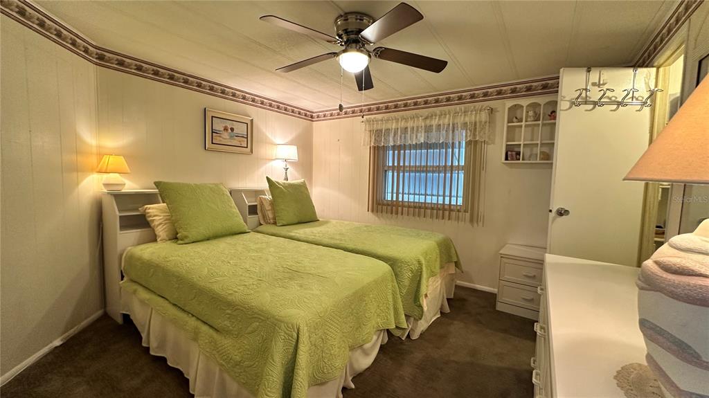 5619 Bayshore Road, Unit 163 Palmetto, FL 34221 - Photo 24 of 44 a spacious bedroom with a bed and a chandelier