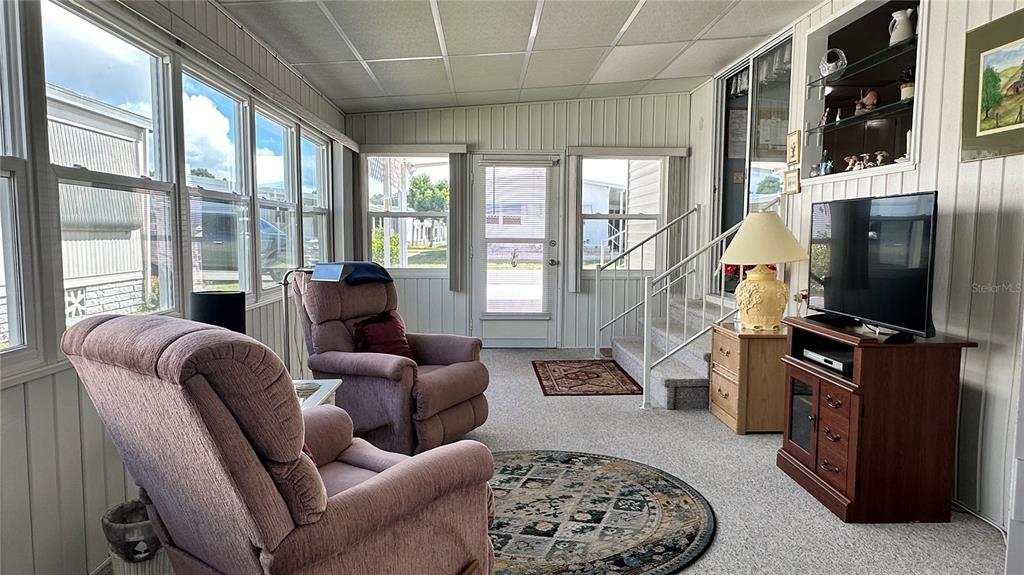 5619 Bayshore Road, Unit 163 Palmetto, FL 34221 - Photo 30 of 44 a living room with furniture a flat screen tv and a floor to ceiling window
