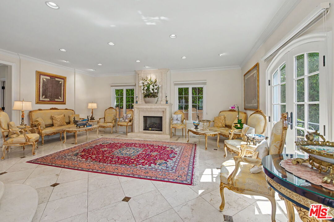 204 Foothill Road Beverly Hills, CA 90210 - Photo 8 of 38 a living room with furniture windows and a fireplace
