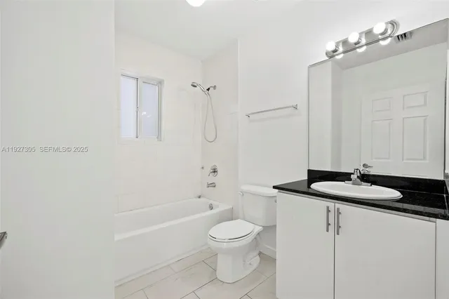 a bathroom with a granite countertop sink toilet a mirror and shower