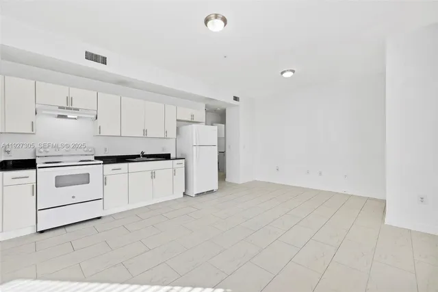 a kitchen with white cabinets and white appliances