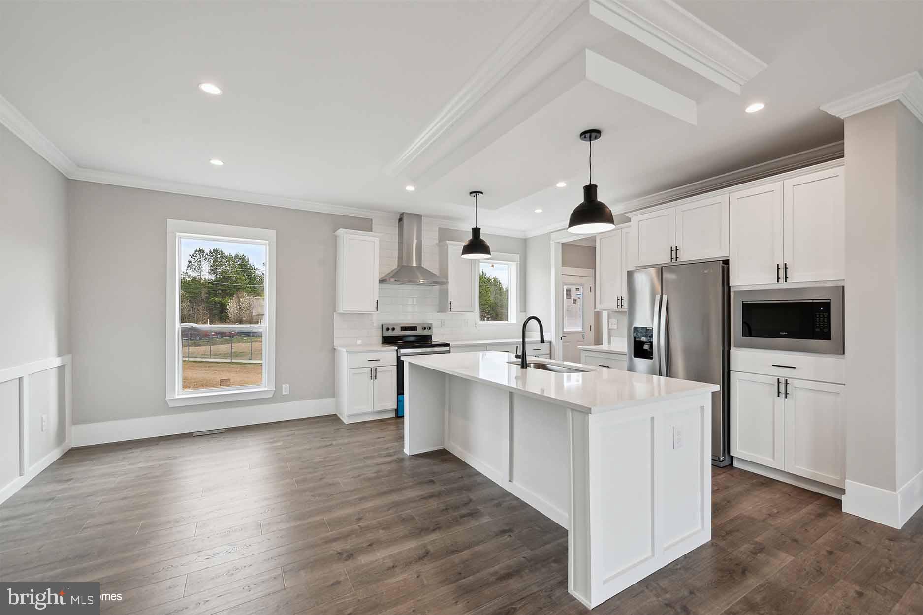 17810 Tyler Station Road Beaverdam, VA 23015 - Photo 2 of 11 a kitchen with stainless steel appliances a stove a sink dishwasher a refrigerator white cabinets and wooden floor next to a window