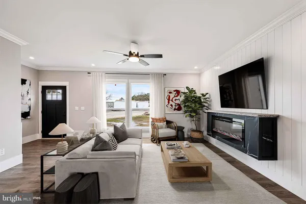 a living room with furniture a flat screen tv and a fireplace