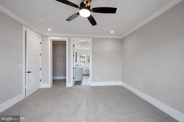 en empty room with closet and a chandelier fan