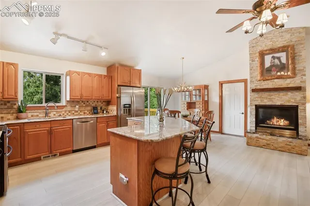 a kitchen with stainless steel appliances a table and chairs in it