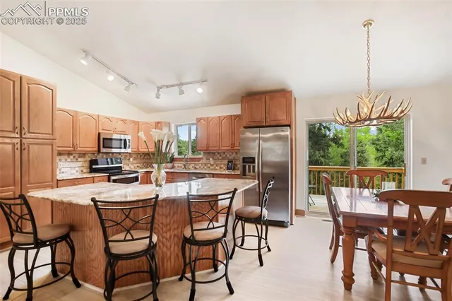 a dining room with furniture a chandelier and wooden floor