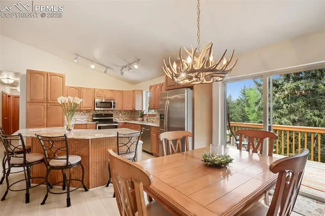 a view of a dining room with furniture a chandelier and wooden floor