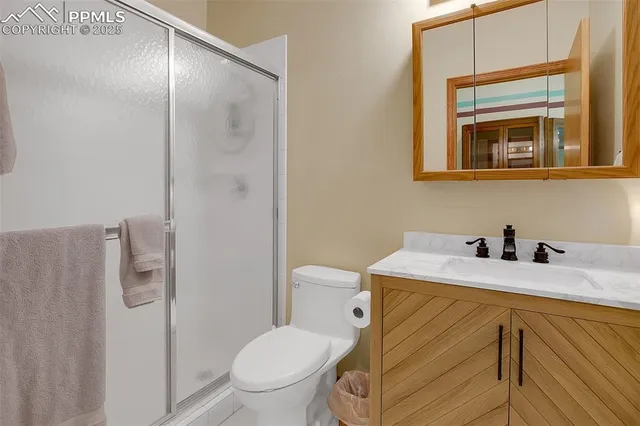 a bathroom with a granite countertop sink toilet and mirror
