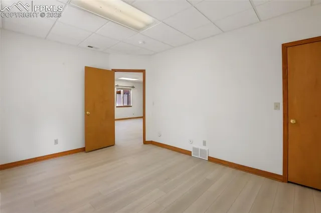 a view of an empty room with wooden floor and closet