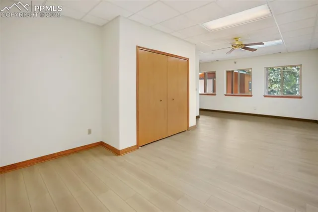 a view of an empty room with window and wooden floor