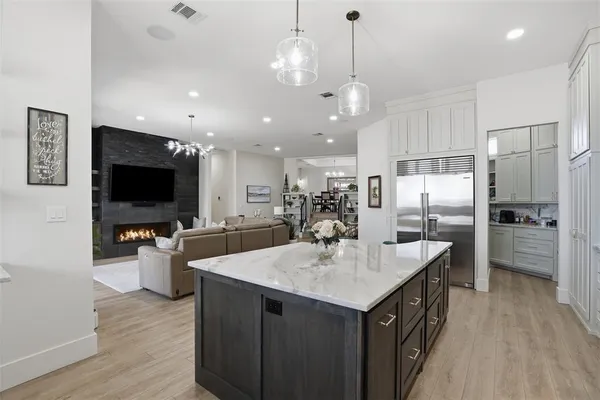 a kitchen with sink a refrigerator and chairs