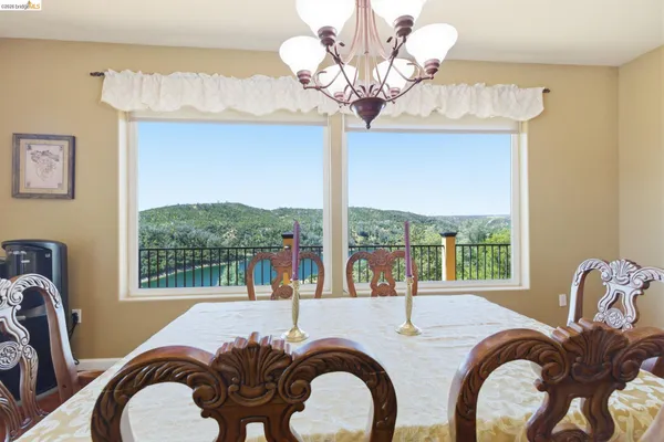 a dining room with furniture a chandelier and large windows