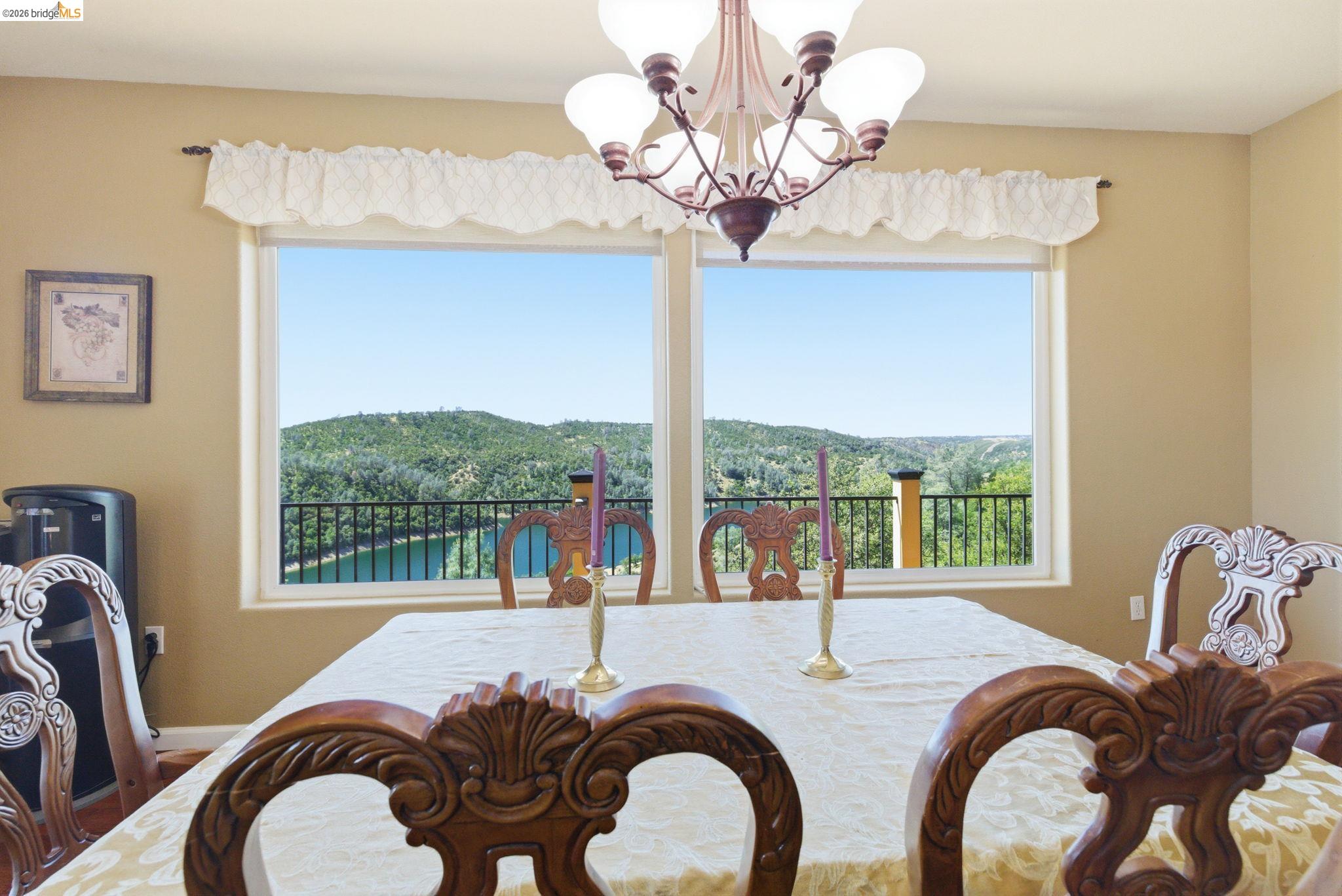 12808 Mammoth Mine Road Jamestown, CA 95327 - Photo 14 of 66 a dining room with furniture a chandelier and large windows