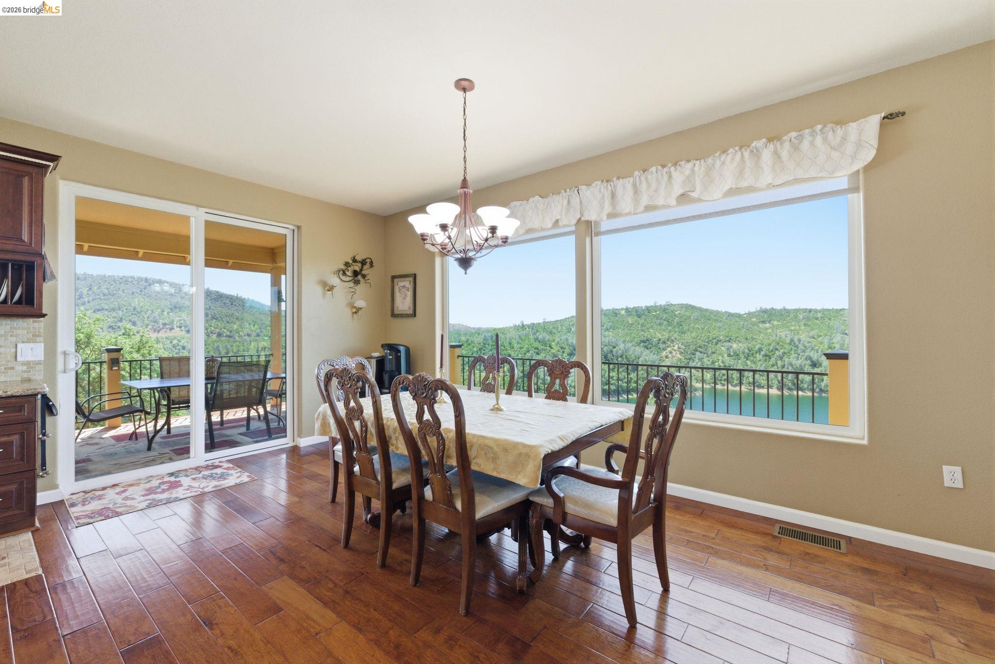 12808 Mammoth Mine Road Jamestown, CA 95327 - Photo 14 of 60 Dining room featuring suspended lighting, a view of trees, and dark wood-type flooring