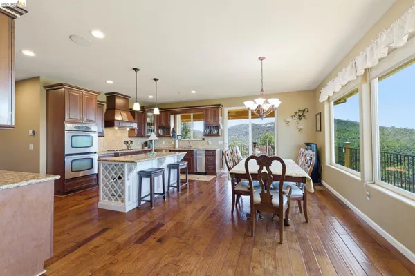 an open kitchen with dining table and stainless steel appliances