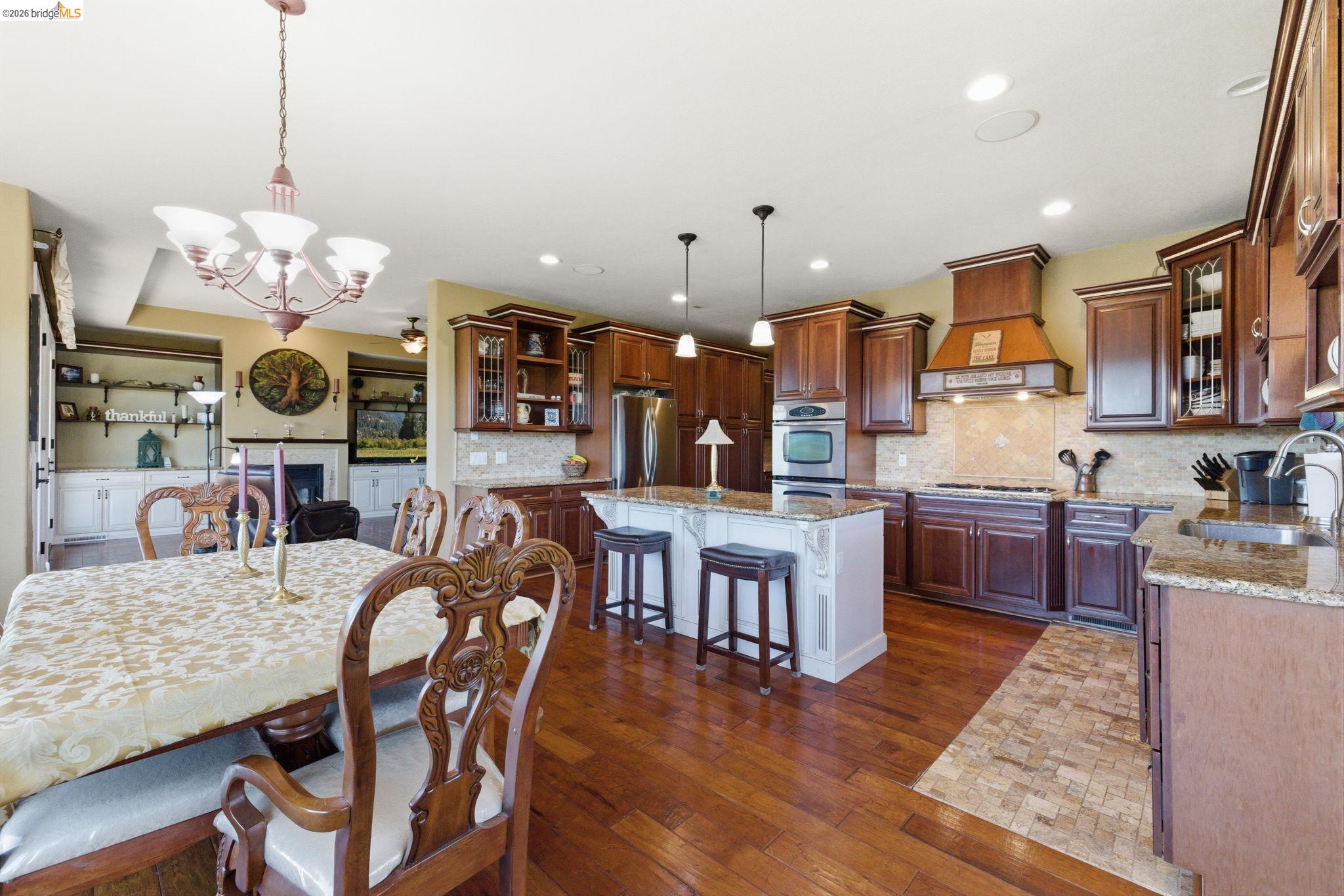 12808 Mammoth Mine Road Jamestown, CA 95327 - Photo 18 of 60 Dining space featuring dark wood-style flooring, a chandelier, and a fireplace