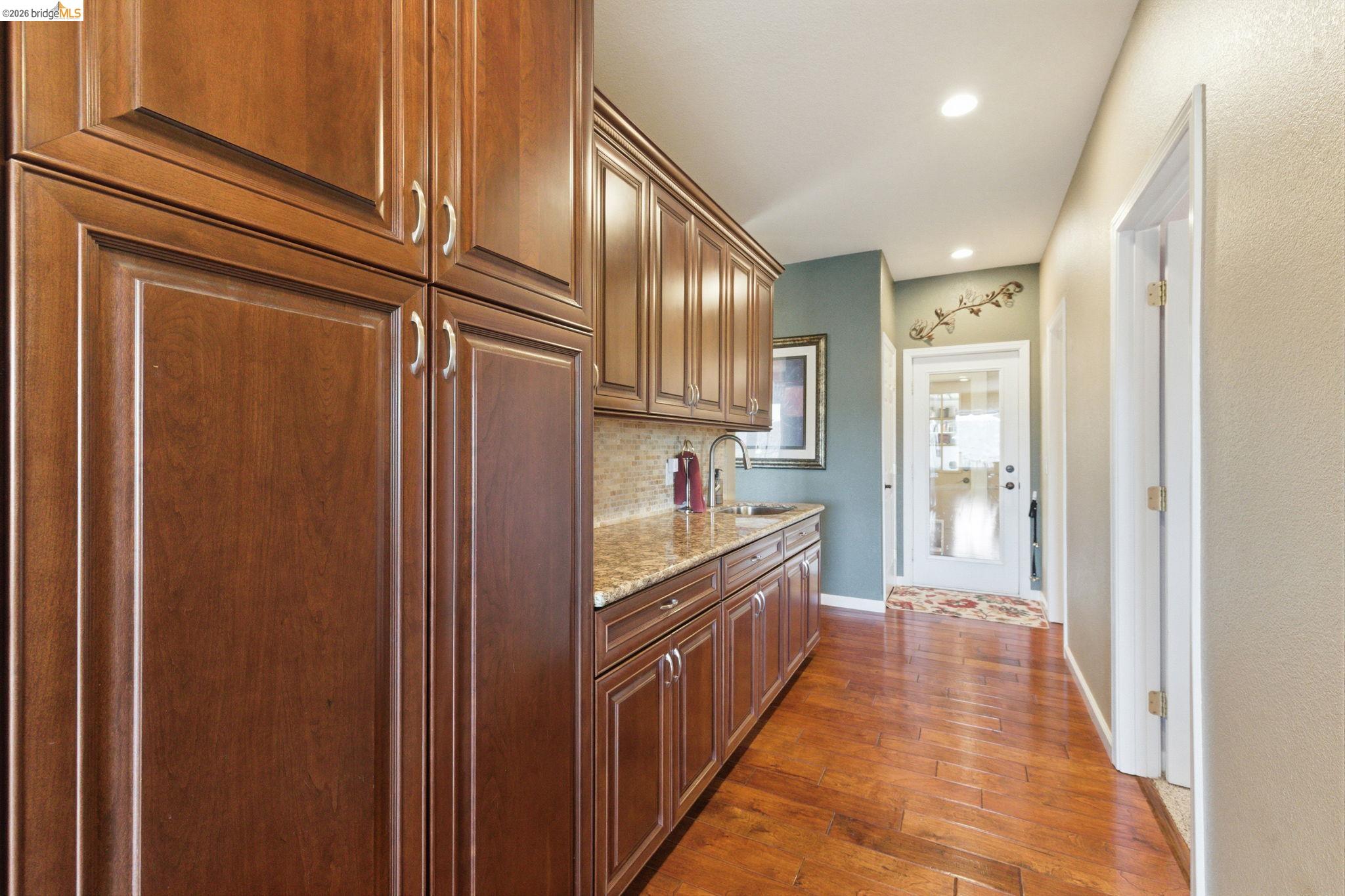 12808 Mammoth Mine Road Jamestown, CA 95327 - Photo 20 of 60 Kitchen featuring dark wood-style floors, light stone countertops, recessed lighting, backsplash, and wood finish cabinetry