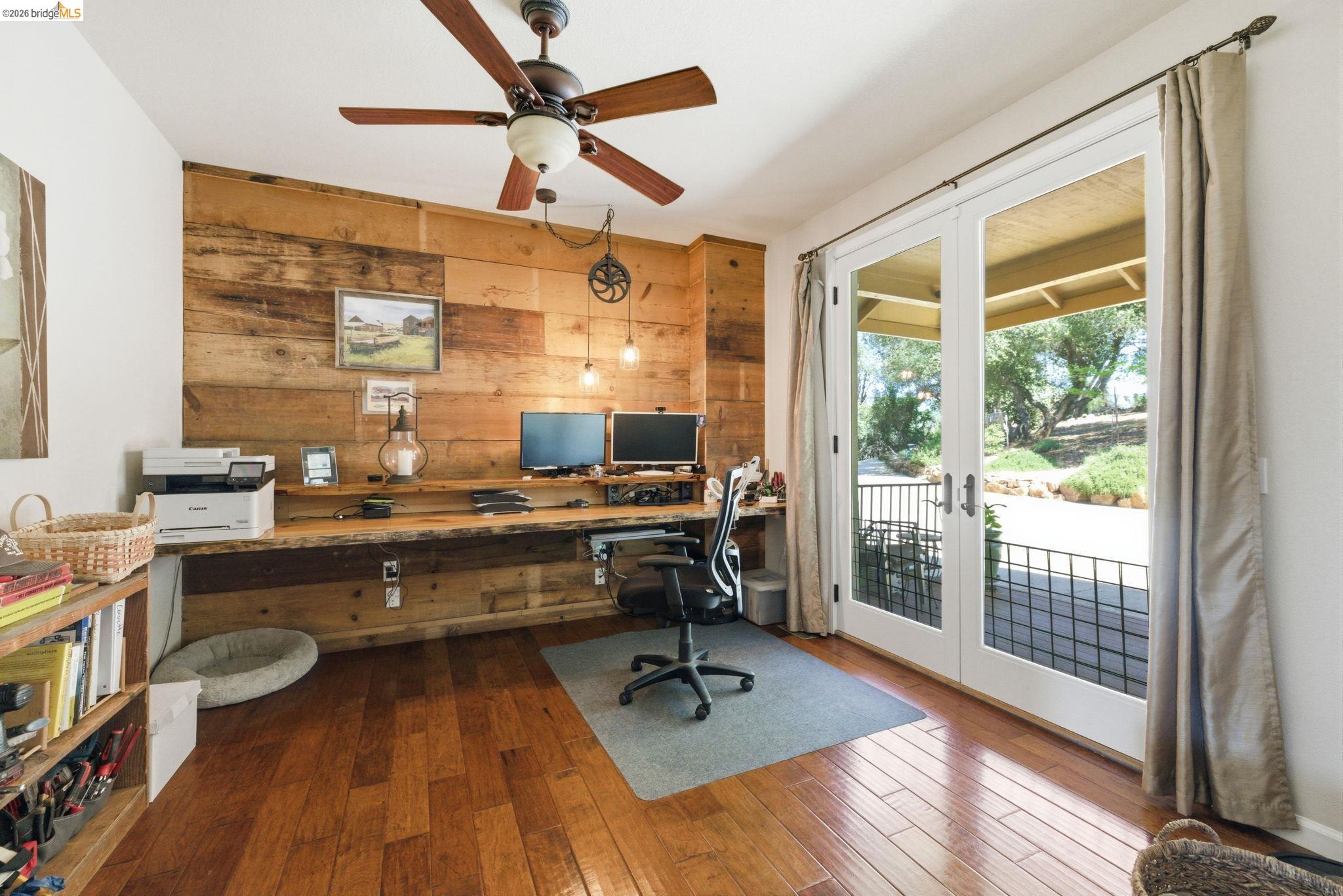 12808 Mammoth Mine Road Jamestown, CA 95327 - Photo 8 of 60 Office space with french doors, wooden walls, dark wood-style flooring, a ceiling fan, and built in desk