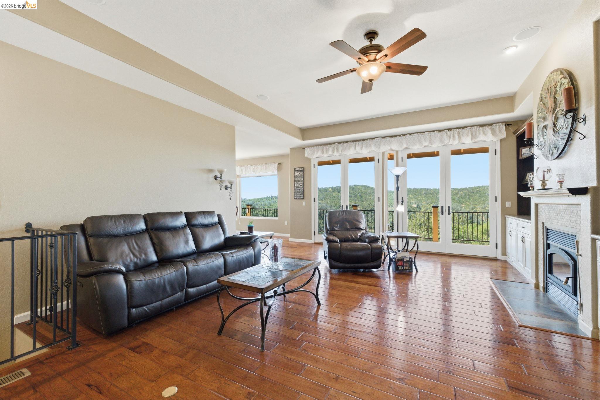 12808 Mammoth Mine Road Jamestown, CA 95327 - Photo 10 of 60 Living area with ceiling fan, french doors, dark wood-style flooring, and a glass covered fireplace