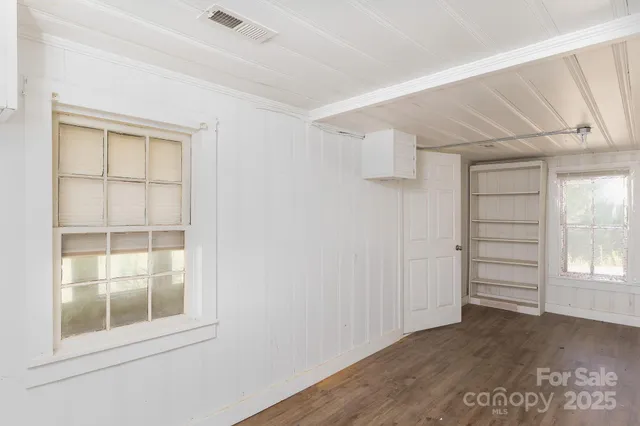 an empty room with windows and closet