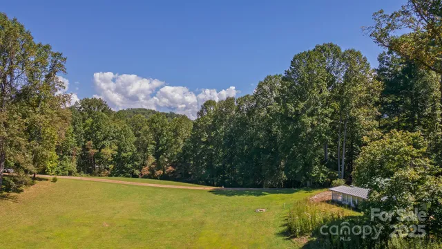 a view of a swimming pool with a patio and yard of the house