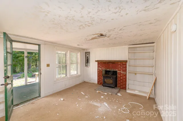 an empty room with fireplace and windows
