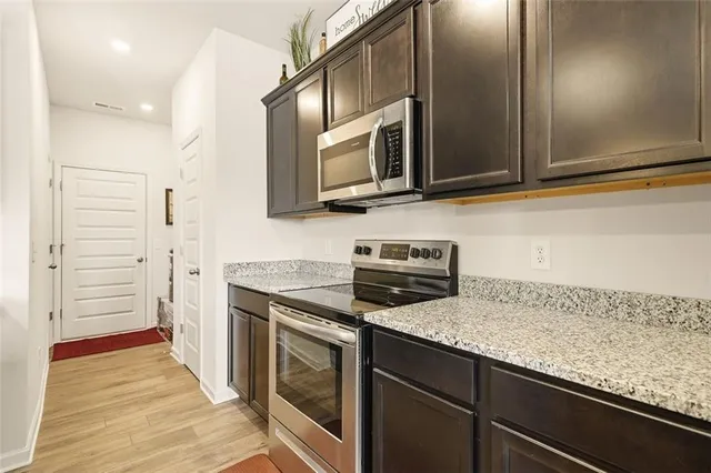 a kitchen with stainless steel appliances granite countertop a sink and a microwave