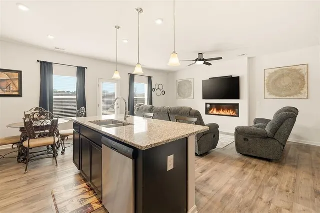 a living room with furniture a flat screen tv and kitchen view