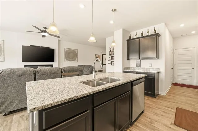 a kitchen with a sink and a stove top oven with wooden floor