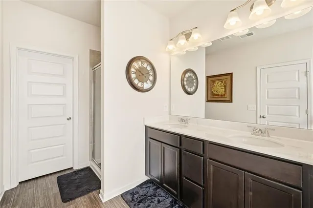 a view of a hallway a kitchen with a stove a mirror and cabinets