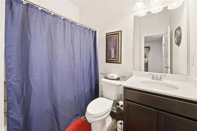 a bathroom with a toilet sink vanity and mirror