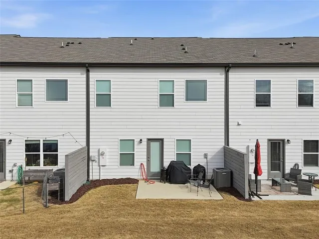 a view of a house with a barbeque and bench