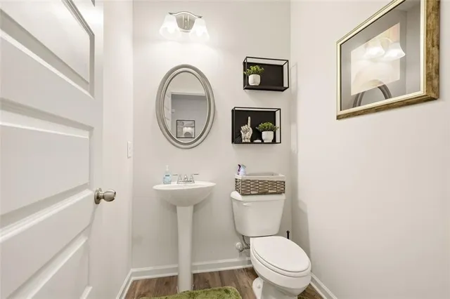 a white toilet sitting next to a bathroom sink and a mirror
